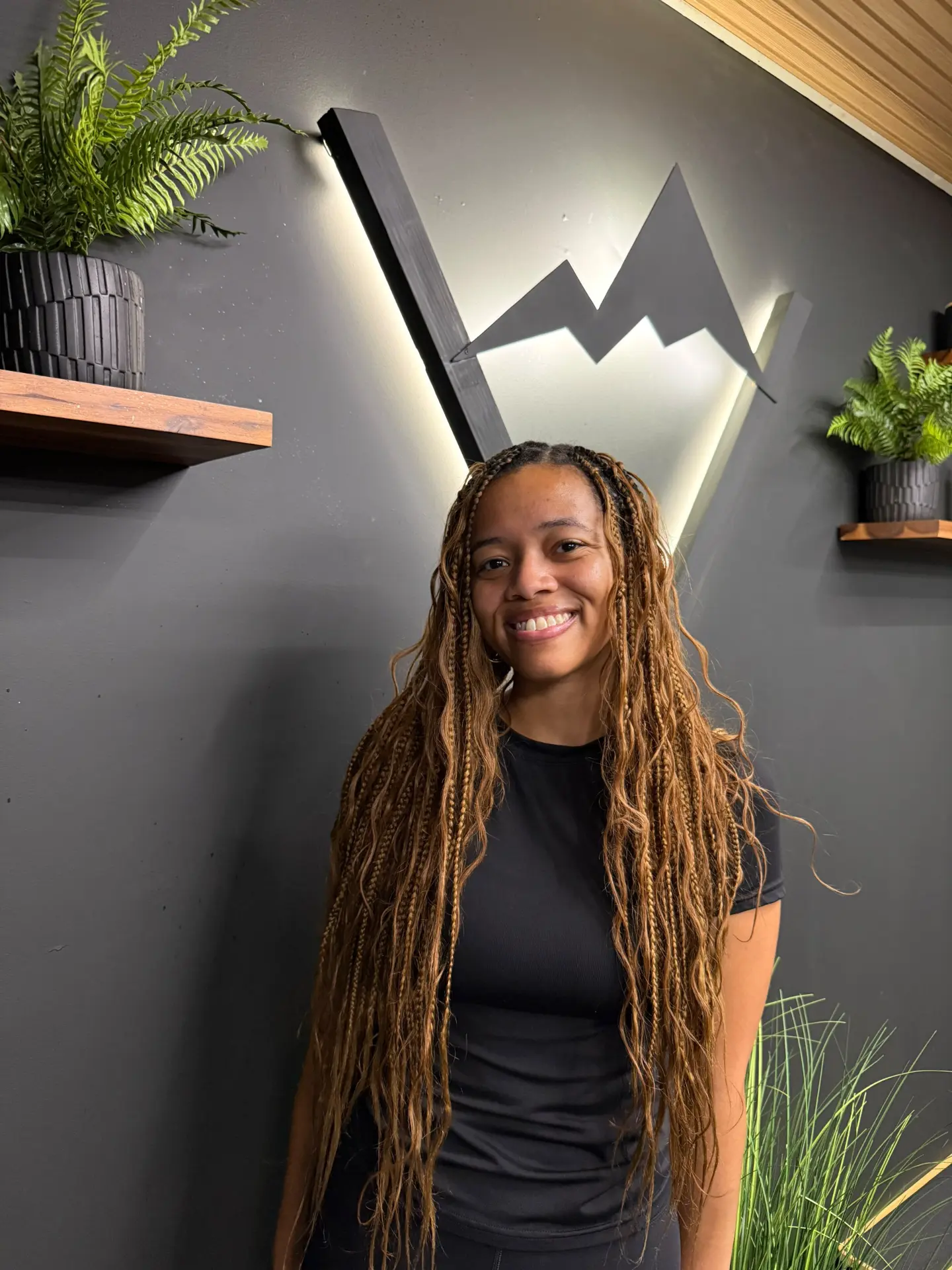 Niara smiling in front of the illuminated Valley Studio mountain logo