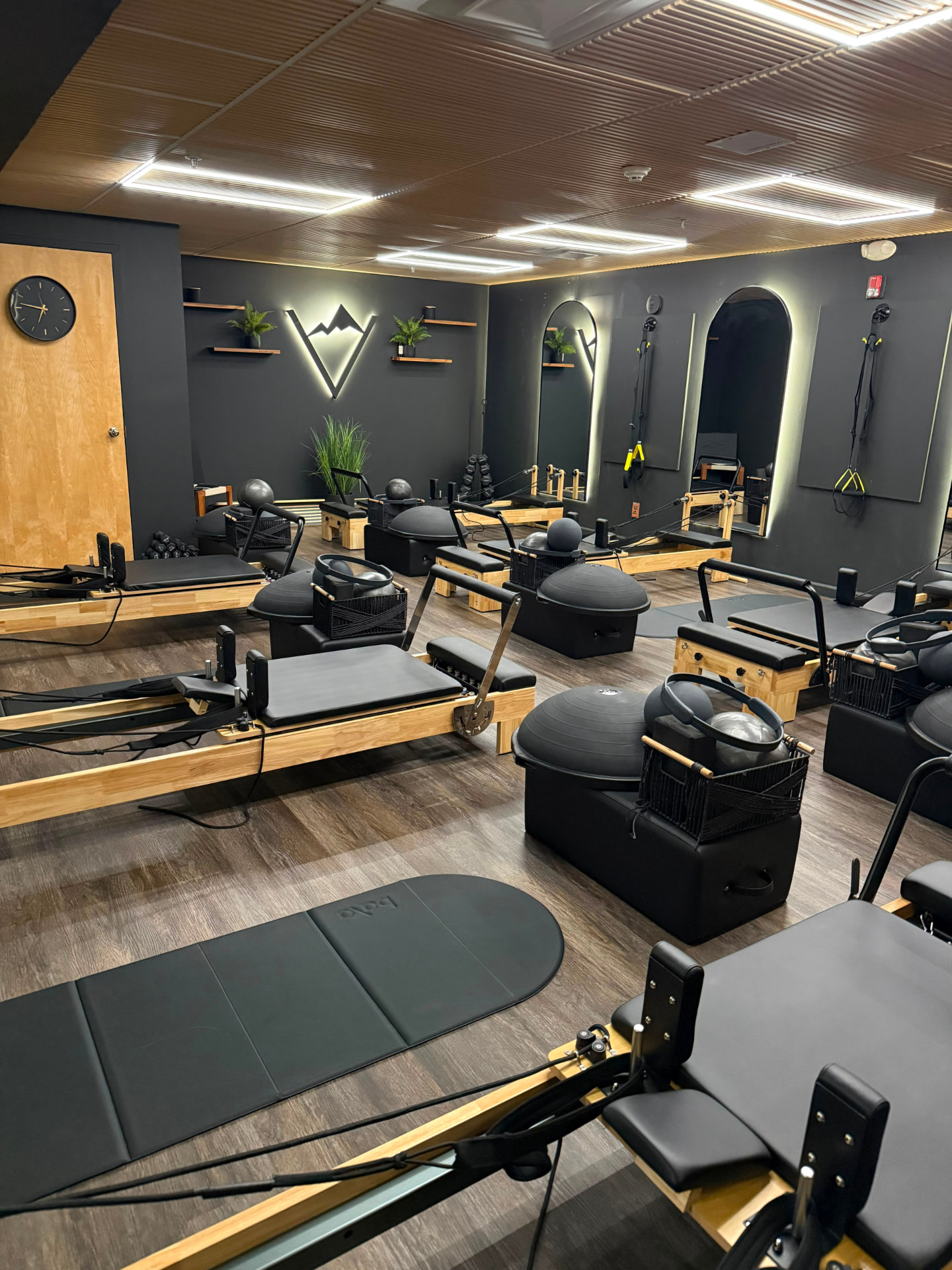 Rows of wooden reformers, stability balls and mats in the Valley Studio training room